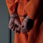 Prisoner with handcuffed arms behind back, another jail transfer, criminal