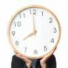 mans hands holding big clock in front of face