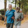 two happy older men walking in the park