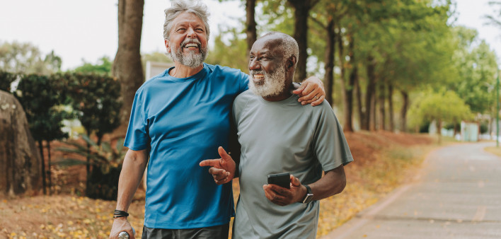 two happy older men walking in the park