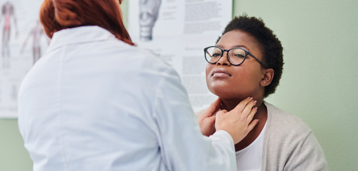 black woman getting thyroid exam