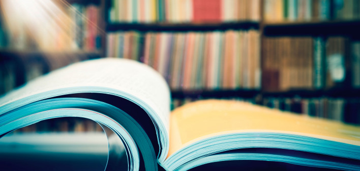 an open book in a libray books on shelf