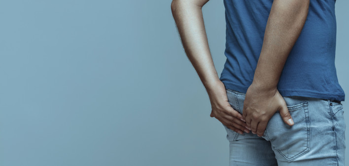 man holds his butt