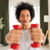 woman holding up red dumb bells