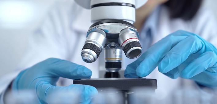 Scientist using microscope in laboratory.