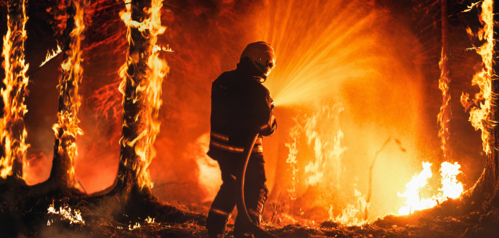 Professional Firefighter Extinguishing Large, High-Priority Part of the Forest Fire.