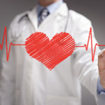 doctor in white coat drawing a red heart on glass