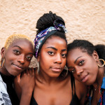 Three smiling black women hugging