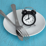 alarm clock on plate with fork and knife fastting diet