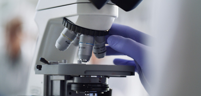 Only from iStock Microscope, laboratory worker or research science for healthcare pharmacy medicine, cancer study or DNA future. Zoom on scientist hands, medical equipment or analytics for covid vaccine for insurance