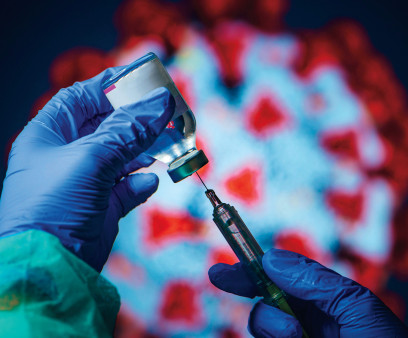 gloved hand needle vial vaccine coronavirus