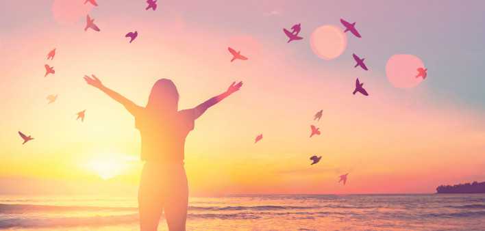 woman arms stretched out sunrise birds beach