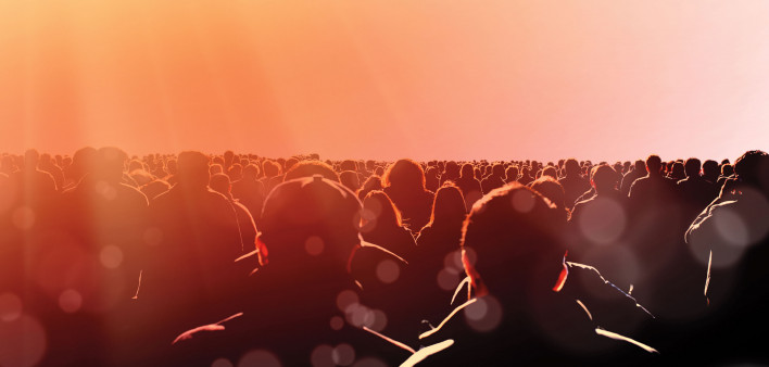crowd of people from behind looking toward light