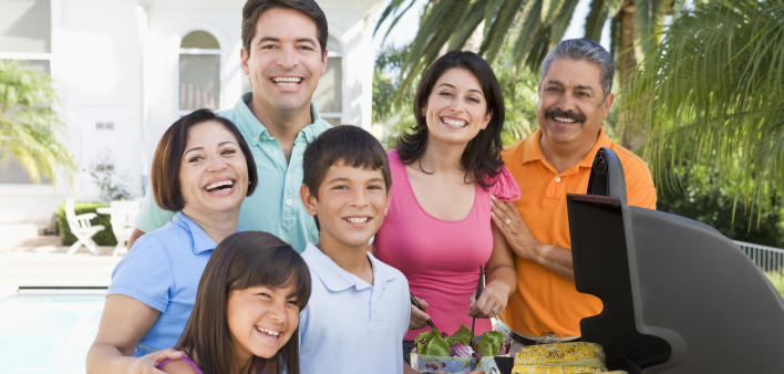 family latino gathered around the grill at a barbecue