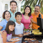 family latino gathered around the grill at a barbecue