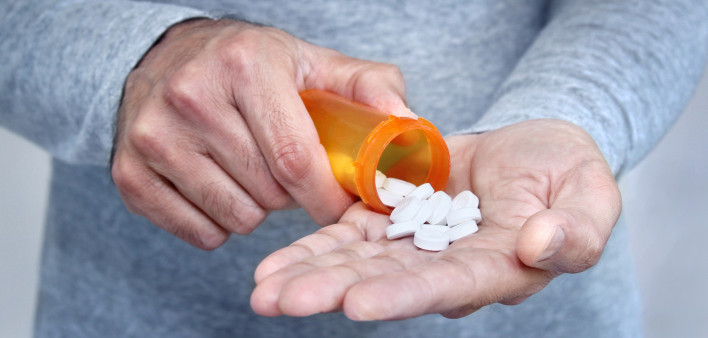 man taking pills pills in his hand