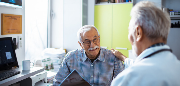 Doctor with x-rays and smiling old man patient