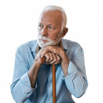 elderly man sitting leaning on his cane