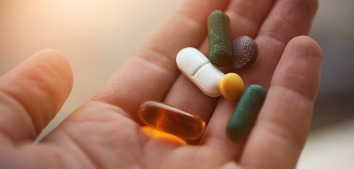 hand holding vitamins and supplements