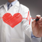 doctor in white coat drawing a red heart on glass