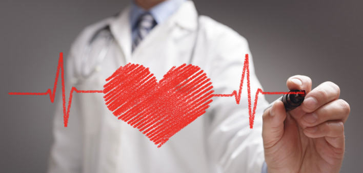 doctor in white coat drawing a red heart on glass