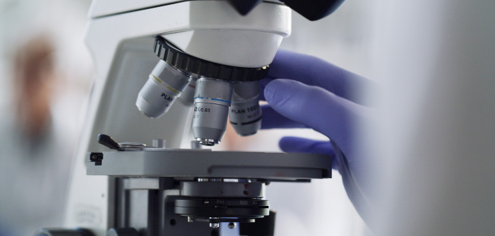 Only from iStock Microscope, laboratory worker or research science for healthcare pharmacy medicine, cancer study or DNA future. Zoom on scientist hands, medical equipment or analytics for covid vaccine for insurance