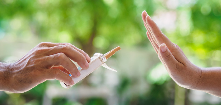lose up of male hands holding cigarettes and proposing it to person.