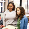 Young Latina girl and mother listen to nurse