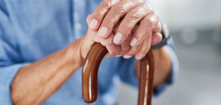 old man's hands on a cane