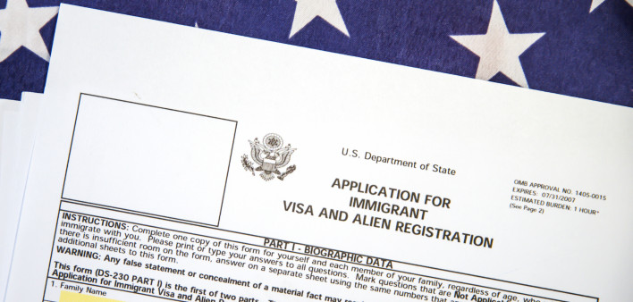 Application form for Immigrant visa and registration with American flag in the backdrop. USA immigrant visa application process