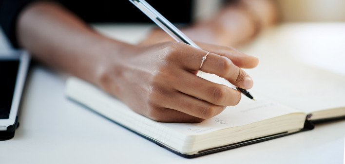 Closeup shot of a businesswoman writing in a notebook in an office