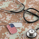 USA military doctor. American flag identification tags and stethoscope on digital camouflage fabric.