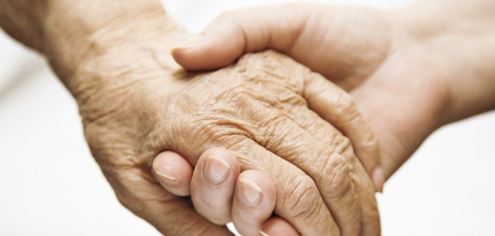 one hand holds the other elderly hand