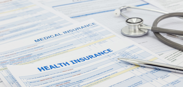 Medical insurance application, silver pen and stethoscope. Legal law contract and health insurance concepts.