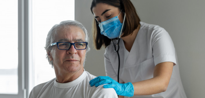 nurse and male pateint listening to lungs