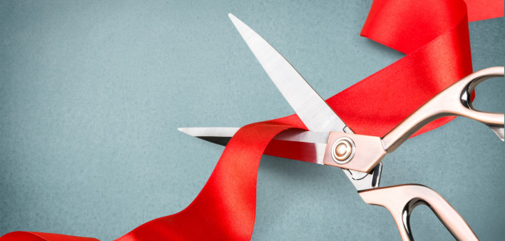 scissors cutting red ribbon