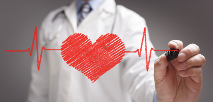 doctor in white coat drawing a red heart on glass