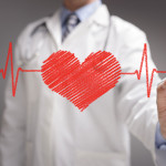 doctor in white coat drawing a red heart on glass