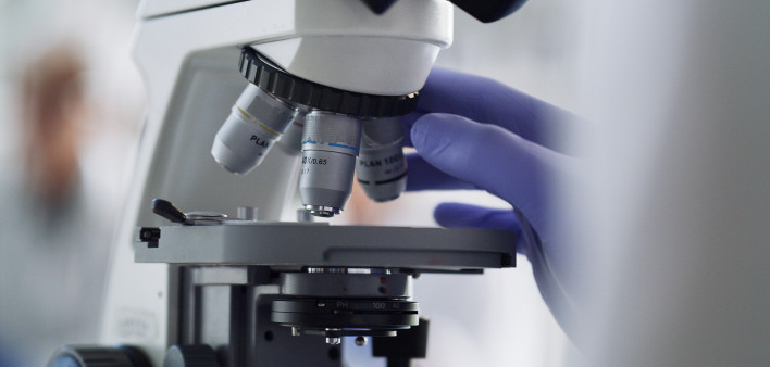 Only from iStock Microscope, laboratory worker or research science for healthcare pharmacy medicine, cancer study or DNA future. Zoom on scientist hands, medical equipment or analytics for covid vaccine for insurance