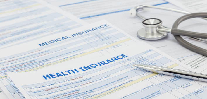 Medical insurance application, silver pen and stethoscope. Legal law contract and health insurance concepts.