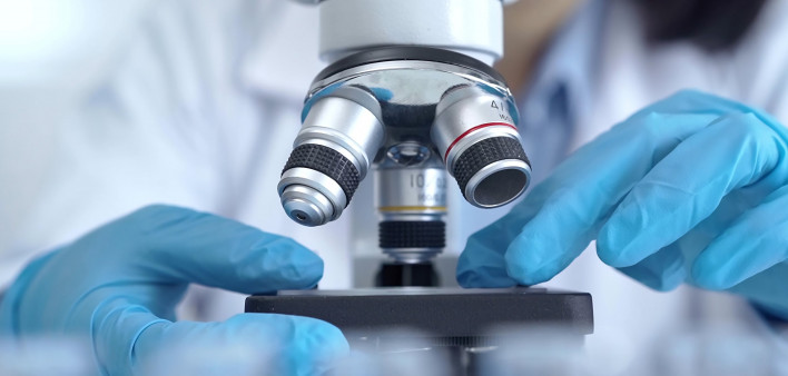 Scientist using microscope in laboratory.