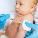 Doctor Giving Vaccination To Baby At Clinic