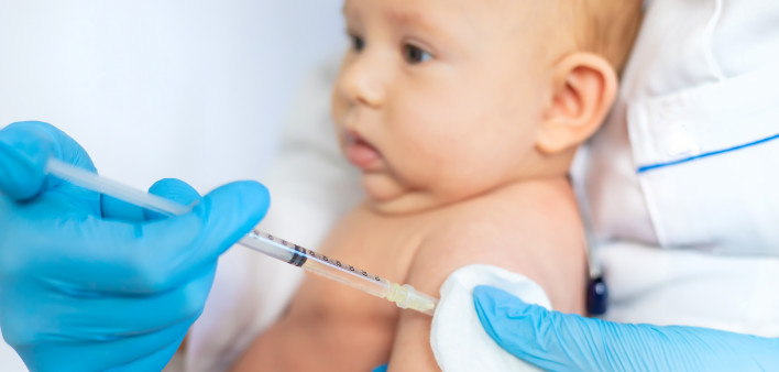 Doctor Giving Vaccination To Baby At Clinic