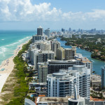Looking down South Beach in Miami. Full view of the beach on the left and the city on the right.