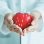 Female medical doctor holding red heart shape in hand with graphic of heart beat, cardiology and insurance concept