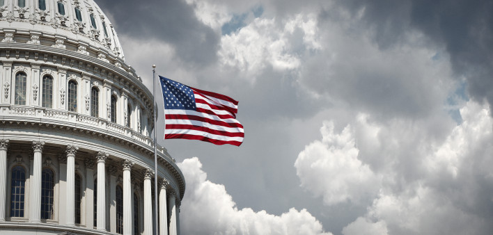 American flag waving with the Capitol Hill in the background