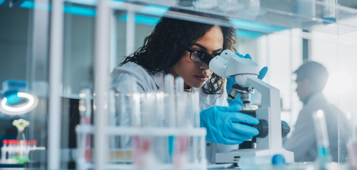 Medical Science Laboratory: Portrait of Beautiful Black Scientist Looking Under Microscope