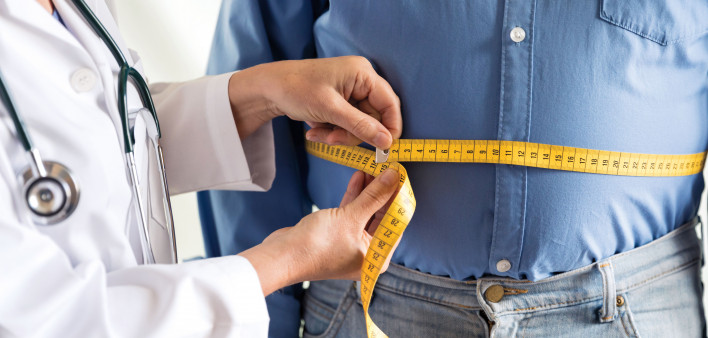 doctor measuring mans stomach