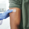 vaccine bandaid on arm hand glove