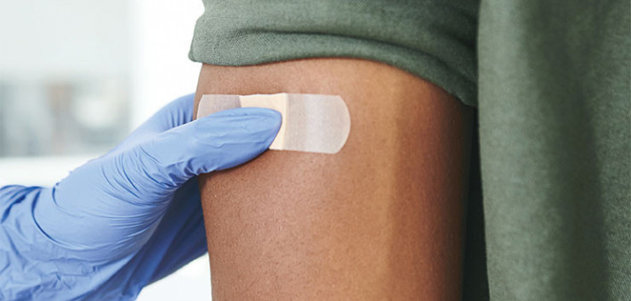 vaccine bandaid on arm hand glove